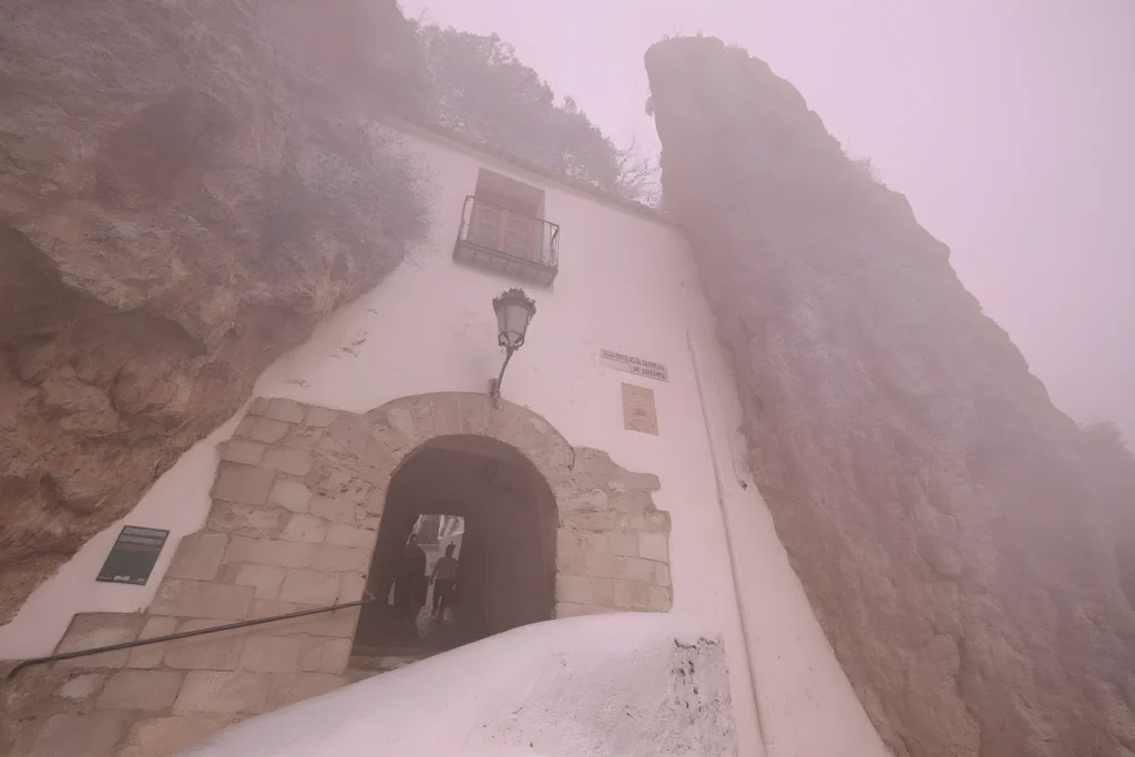 Fachada de piedra de Cases Noves en el casco histórico de Guadalest con macetas de flores