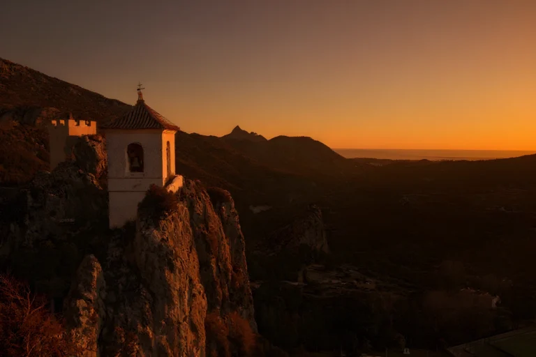 Vista panorámica del embalse turquesa de Guadalest desde el mirador con el castillo al fondo
